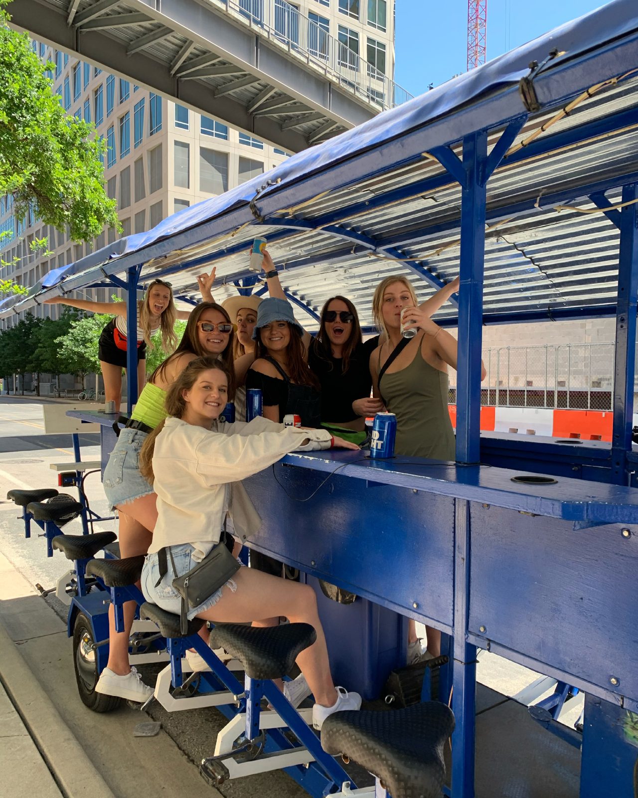 Riders seated around the bar rail of a 15-seat electric bike bar in Austin with drinks and coolers