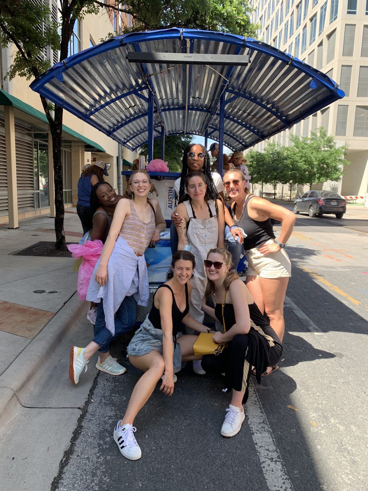 A birthday group posing with the electric Austin Bar Bike in downtown Austin
