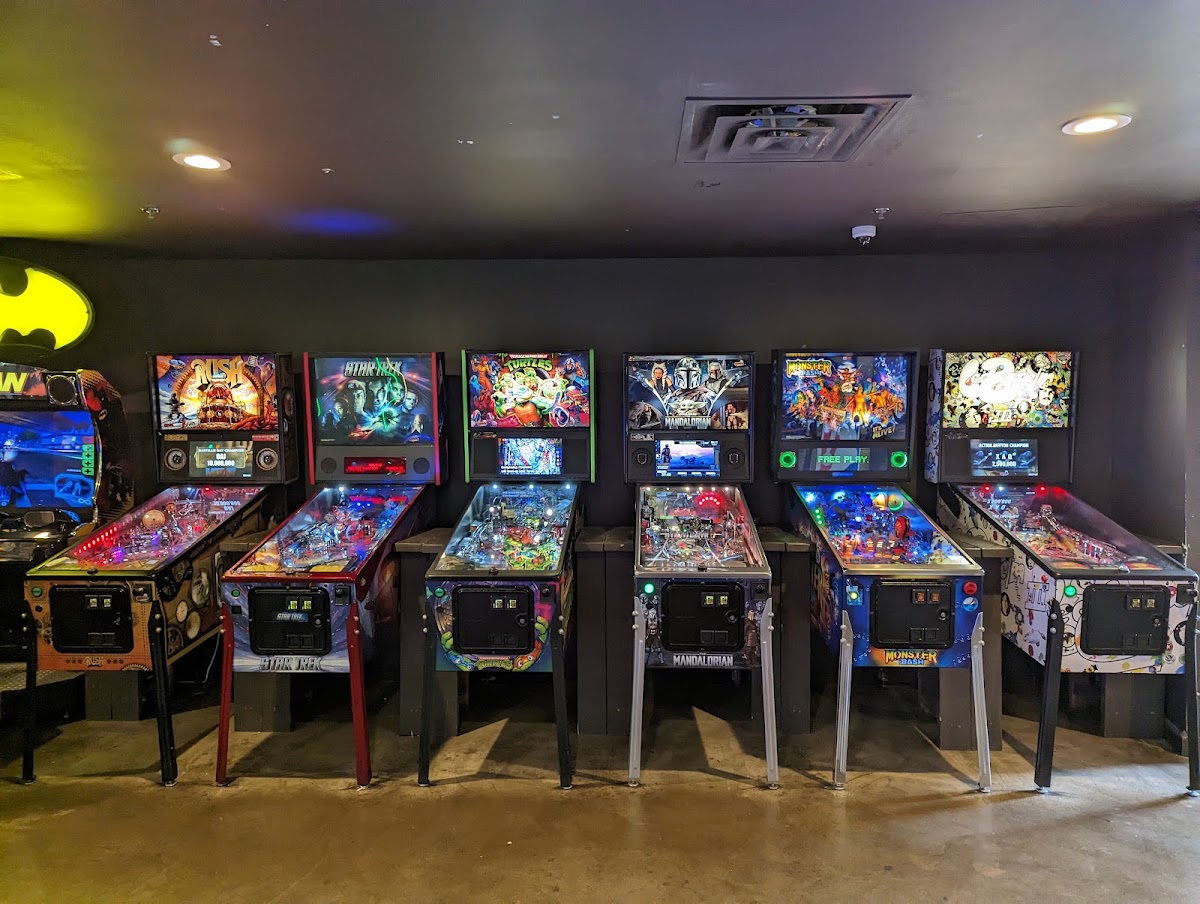Rows of glowing pinball and arcade machines inside Cidercade Austin on East Riverside