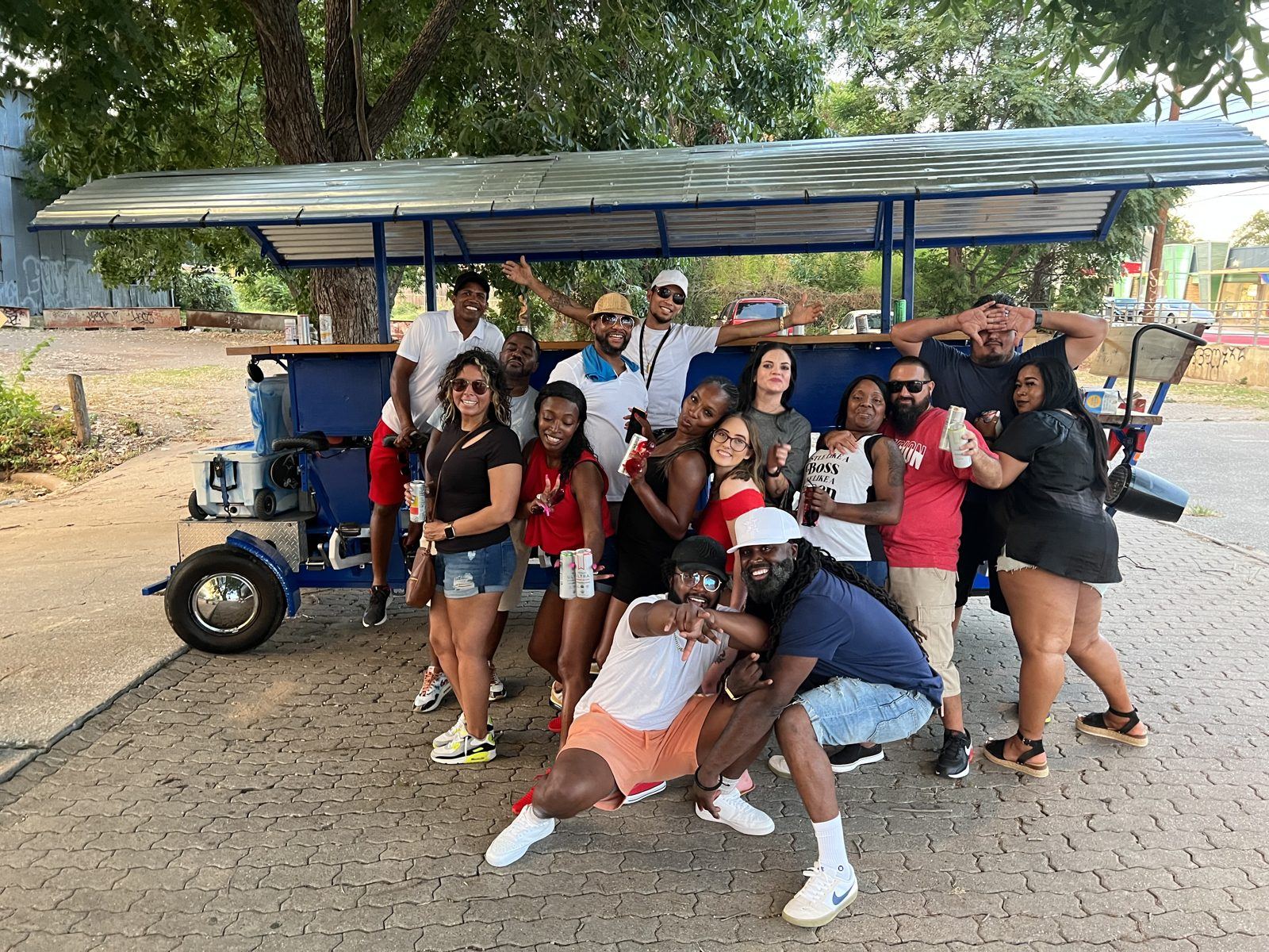 A work team of about fifteen people pedaling the electric Austin Bar Bike through downtown Austin on a weekday afternoon