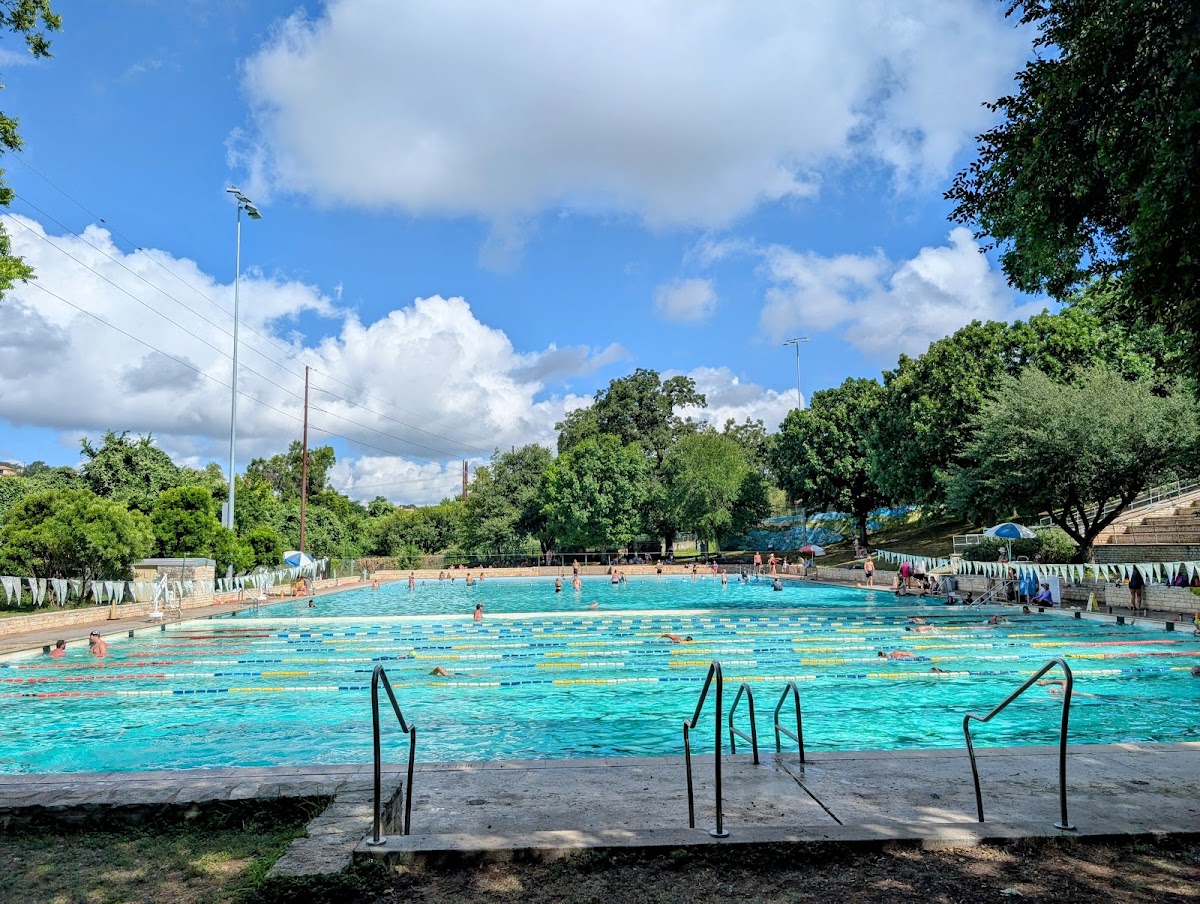 Swimmers and shade trees at Deep Eddy Pool, the oldest swimming pool in Texas, in Austin