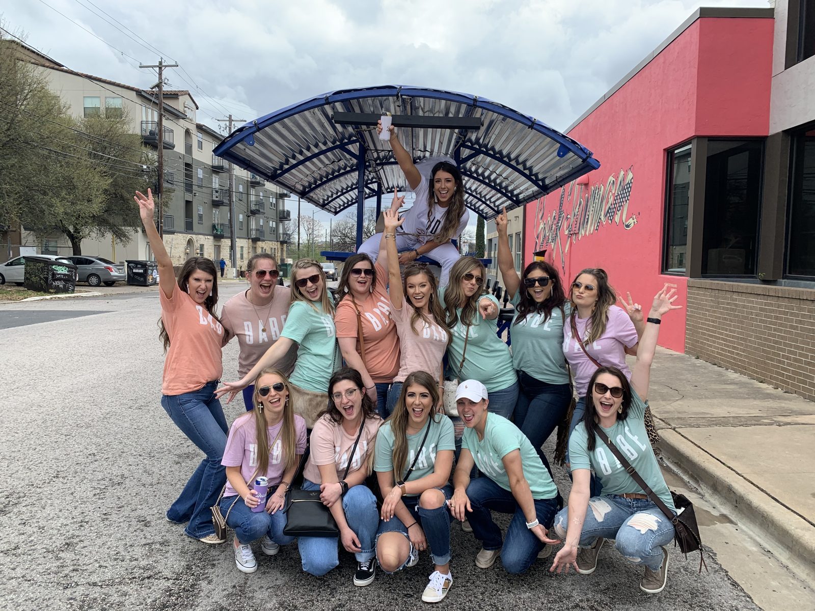 A group of friends posing with the Austin Bar Bike on a downtown Austin street