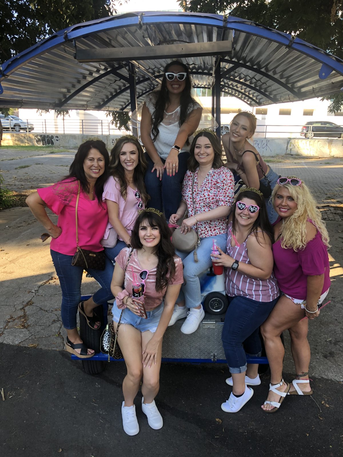 A group aboard the fully electric Austin beer bike with their hands up and nobody pedaling