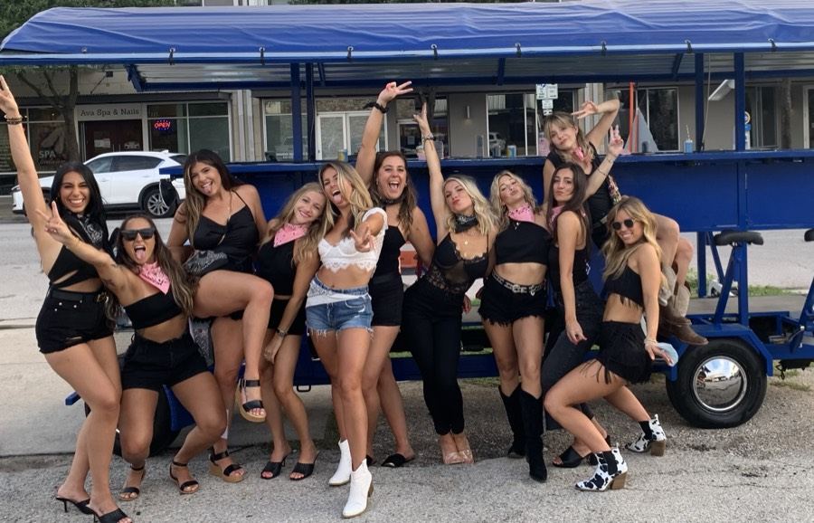 A big bachelorette group cheering in front of the Austin Bar Bike