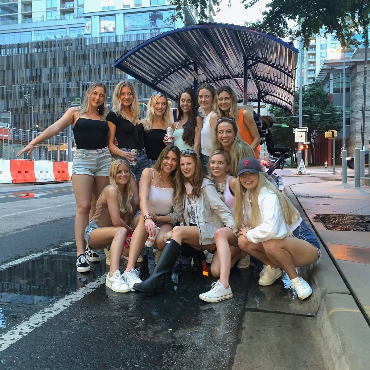 A big group downtown at dusk with drinks up beside the beer bike