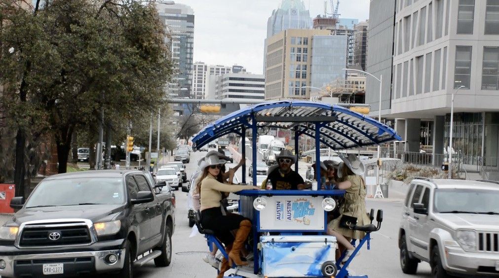 The Austin Bar Bike rolling through downtown Austin with a group aboard