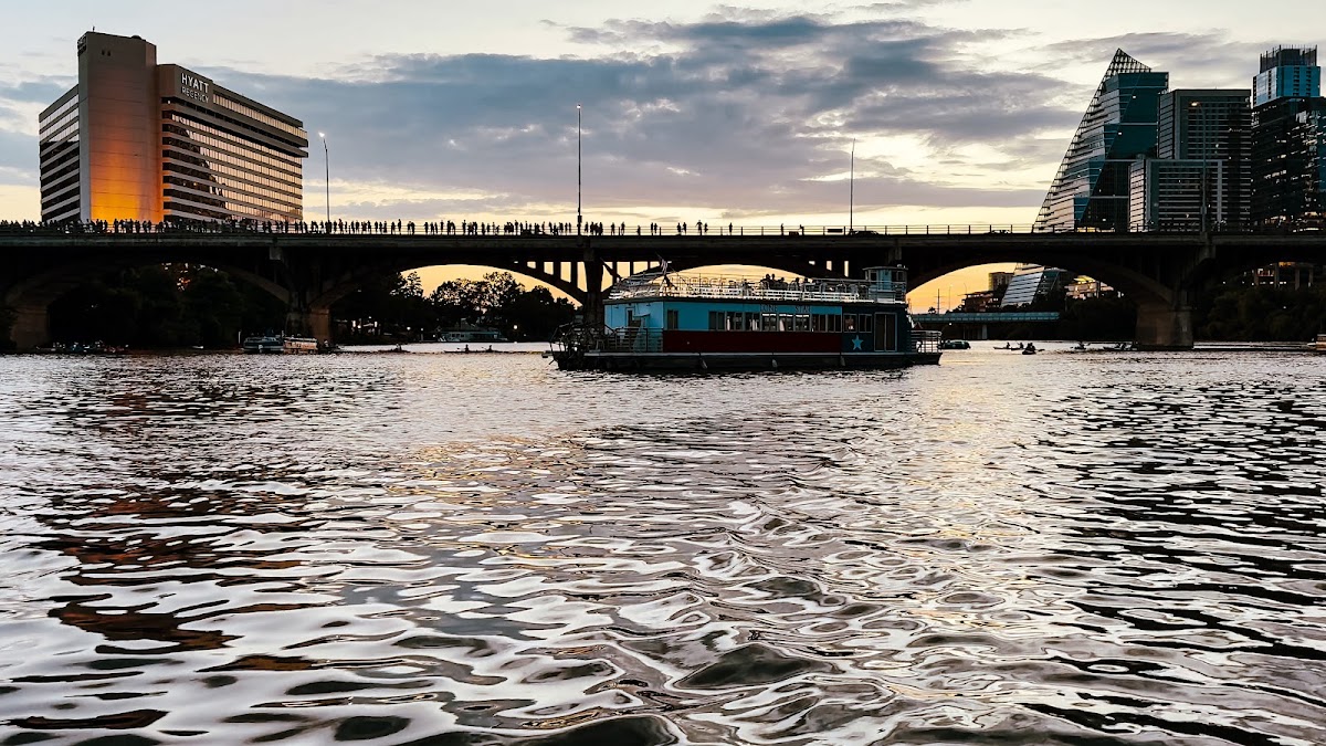Private charter boat on Lady Bird Lake with the downtown Austin skyline behind it