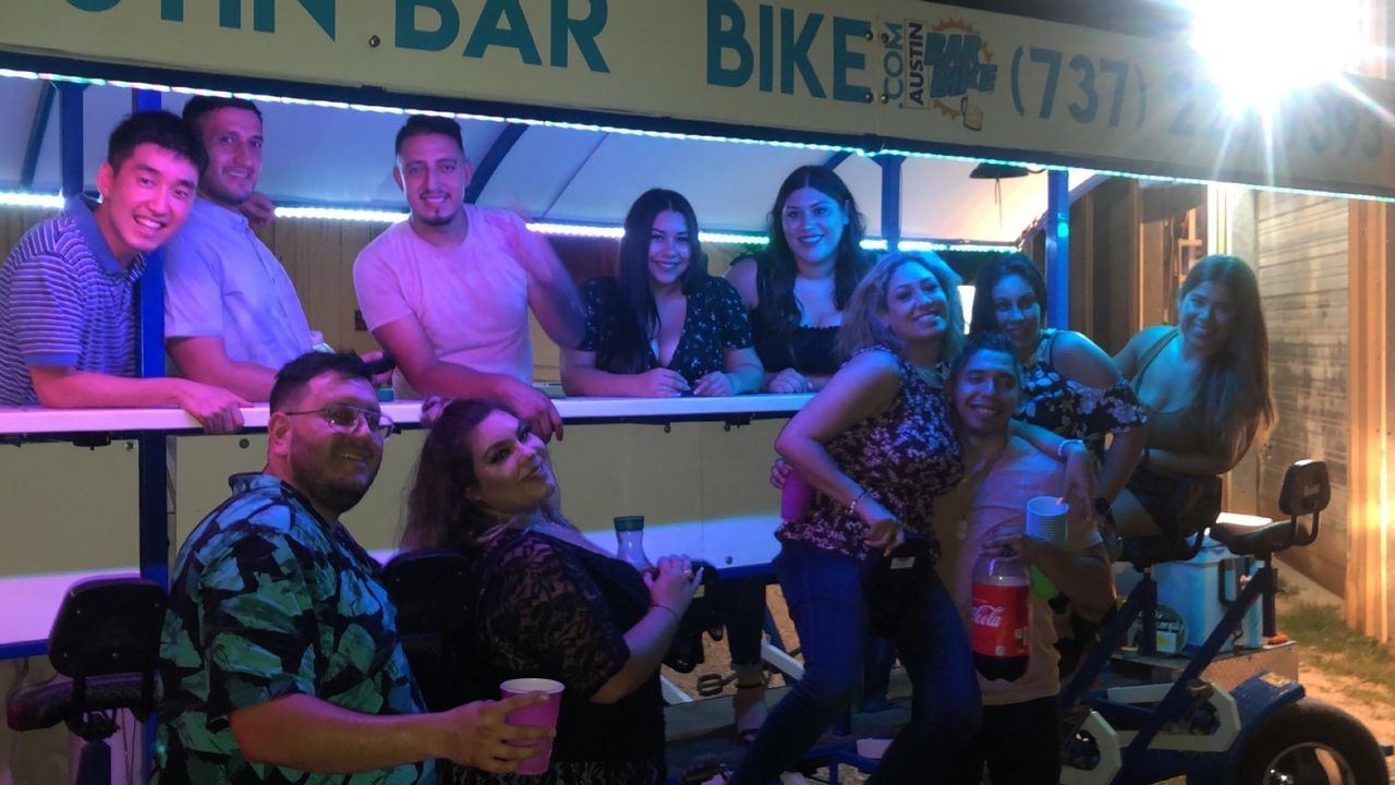A bachelorette group stepping off the electric party bike at a downtown Austin bar stop