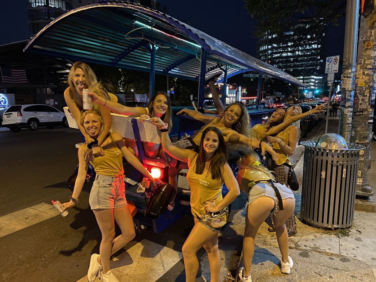 A group riding the 15-seat electric Austin Bar Bike through downtown Austin on a summer evening